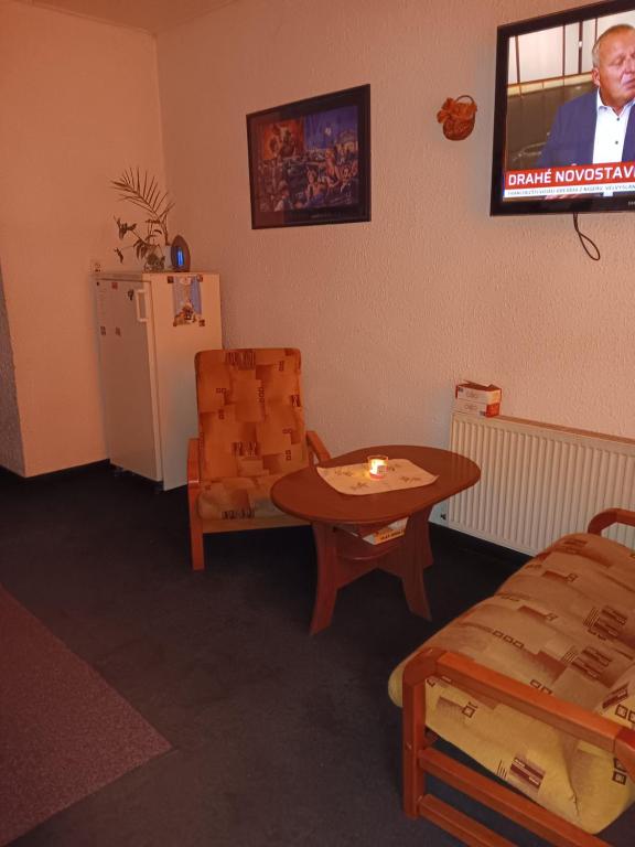 俄斯特拉发Ubytovna u hospůdky的配有桌子、椅子和电视的房间