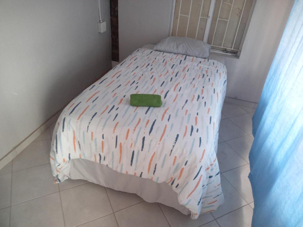 比勒陀利亚Las Palmas Day & Night Guest House的一间卧室配有一张带五颜六色棉被的床