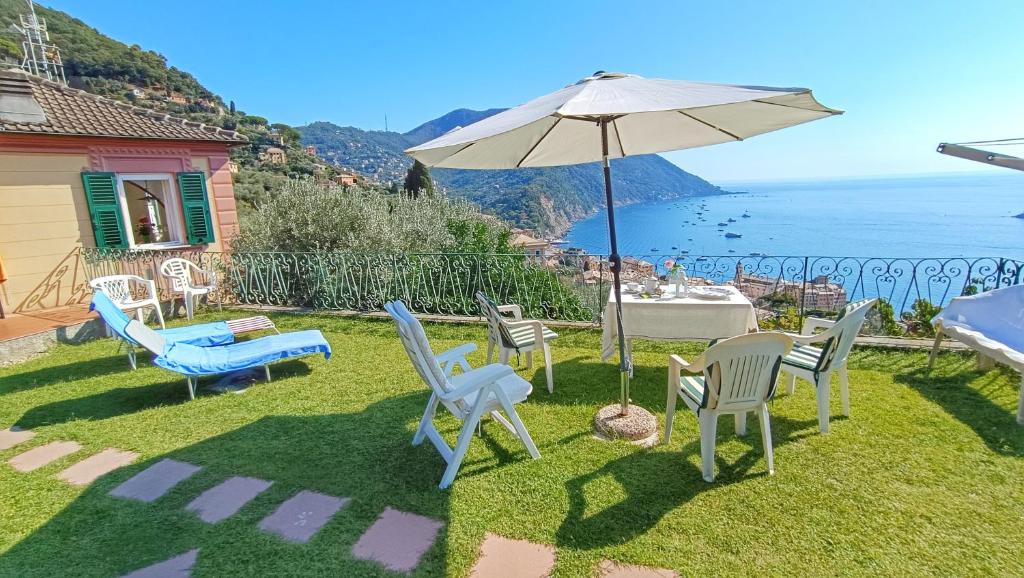 卡莫利Villa Mortola的庭院配有桌椅和遮阳伞。
