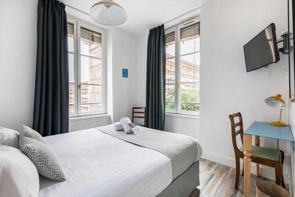 里昂辛普龙酒店的卧室配有一张床、一张书桌和窗户。