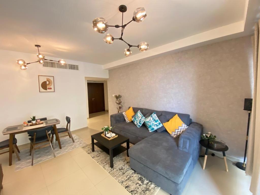 拉斯阿尔卡麦Beach Dream - a luxury 1 bedroom apartment with direct beach access的客厅配有蓝色的沙发和桌子