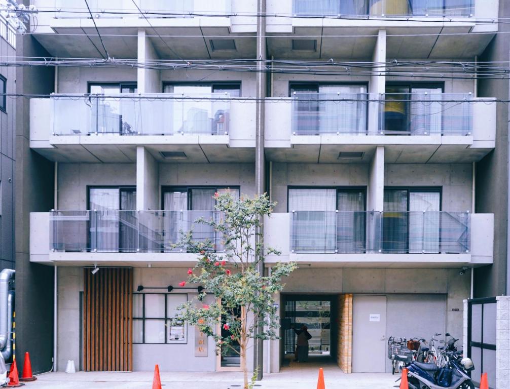 大阪Rest Kujo Apartment的带阳台的建筑,前面有一棵树