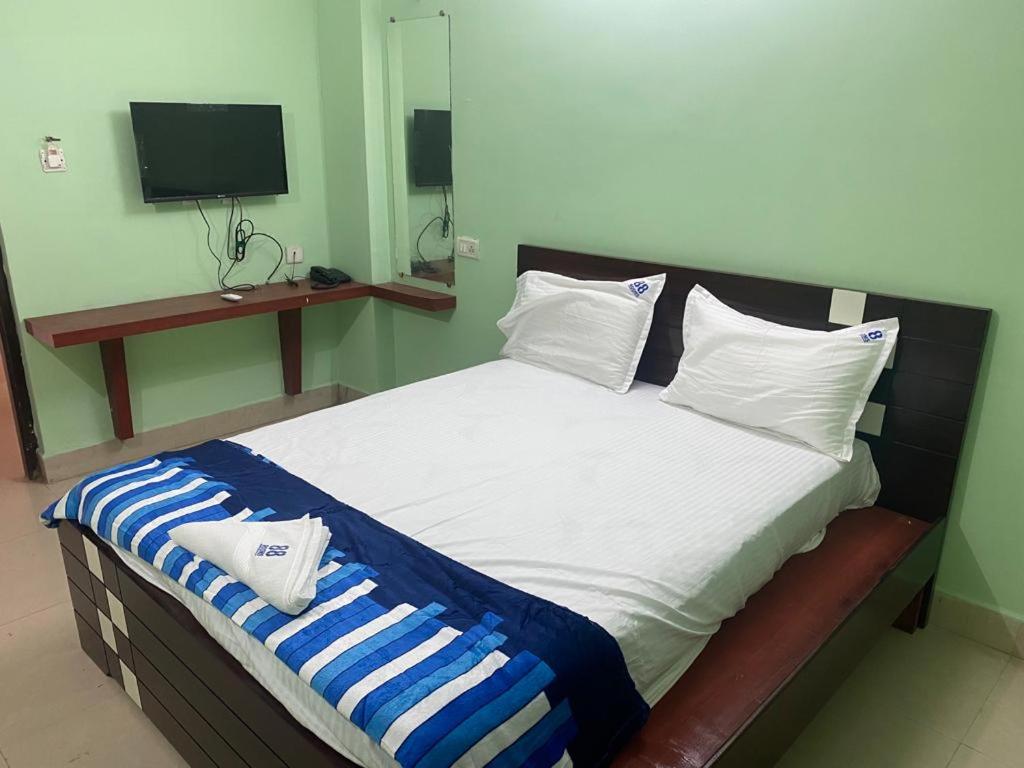 OngoleARUDRA BUDGET suites的一间卧室配有一张带蓝白色枕头的大床