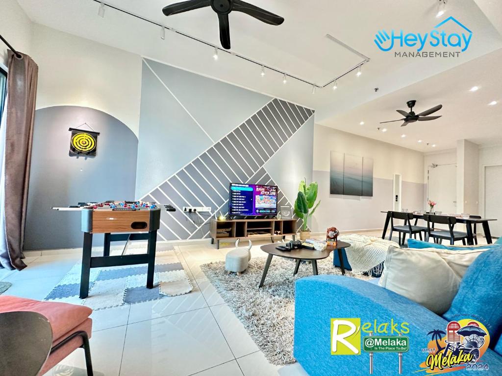 马六甲OngKimWee Residence By Heystay Management的客厅配有蓝色的沙发和桌子