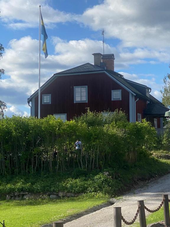 SöderbärkeHandlarens villa - Vandrarhem de luxe的前面有旗帜的红色房子