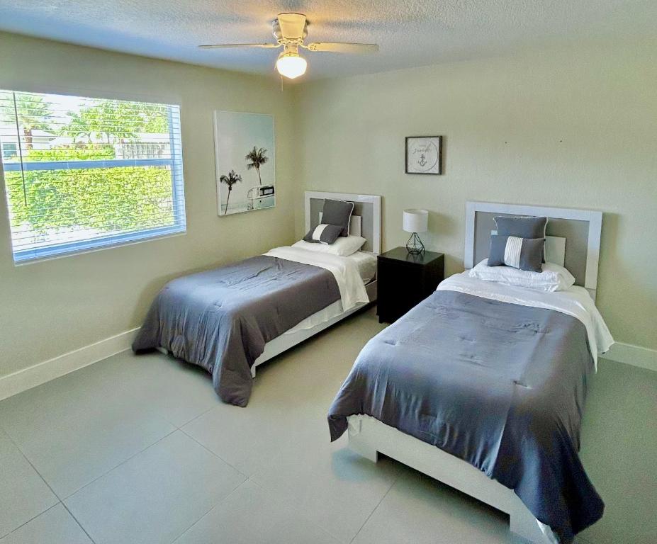 西棕榈滩Casa Flamenco的一间卧室设有两张床和窗户。