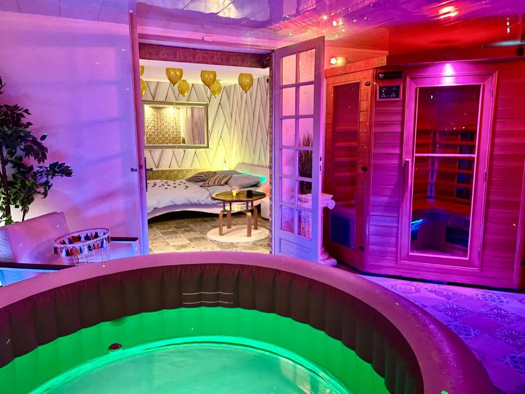 GagnyEspace détente jacuzzi sauna的紫色和绿灯的房子里的一个游泳池