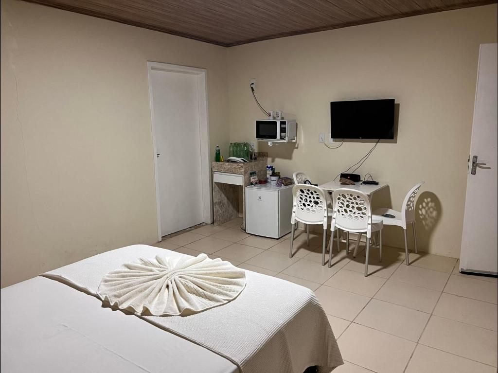 伊塔帕里卡岛维拉克鲁兹Flat - Condomínio Fechado - Frente Mar的一间卧室配有一张床、一张书桌和一台电视