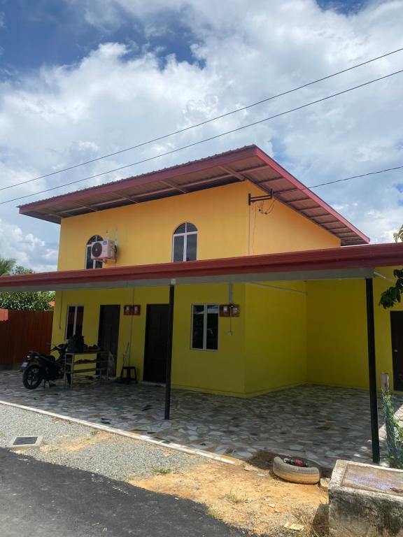 TuaranElijah’s Tiny House的黄色的房屋,有红色的屋顶