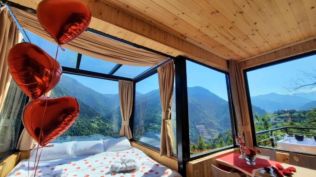 巴统Villa Machakhela●ვილა მაჭახელა的一间卧室设有一张床和一个大窗户
