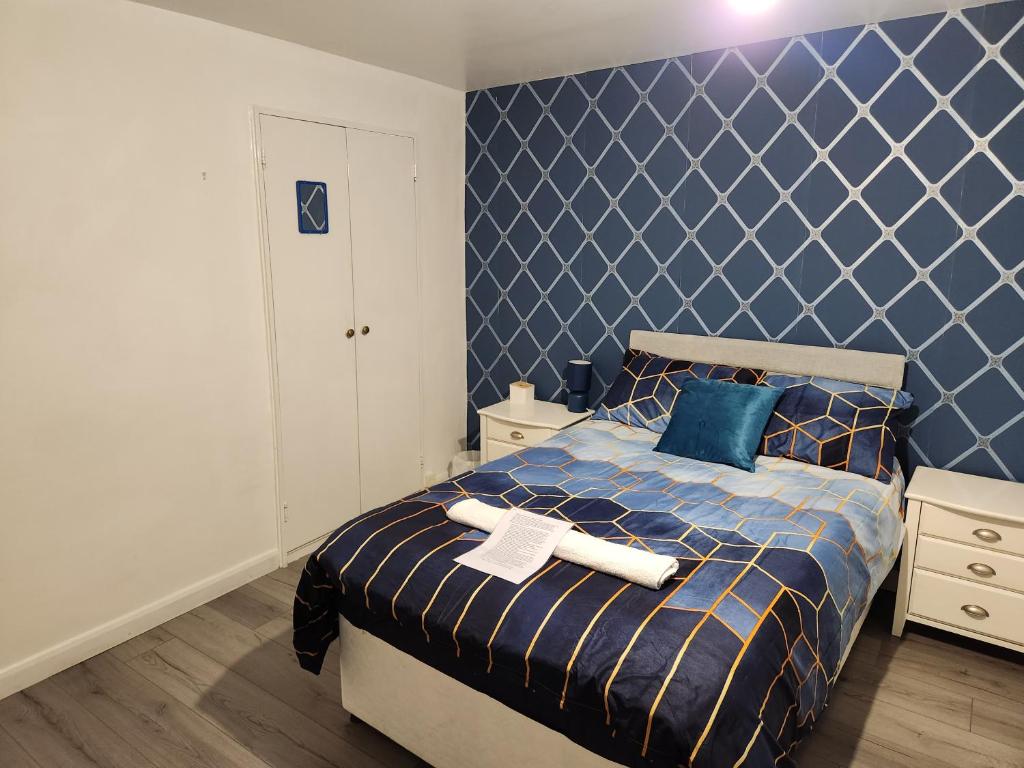 克劳利Swift Stop Night Stay - Gatwick的一间卧室配有一张蓝色墙壁的床