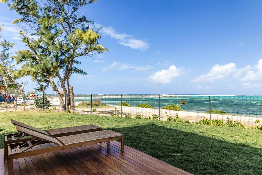 Poste LafayetteOcean Terraces Apt A1 - Your Beachfront Bliss - Brand NEW的木甲板设有长凳,享有海景