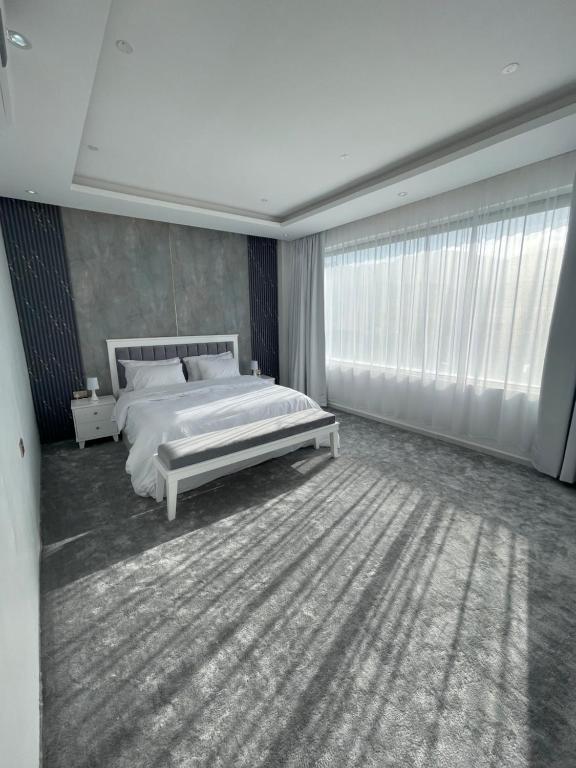 尼兹瓦Al ATLAL apartment的卧室设有白色的床和大窗户