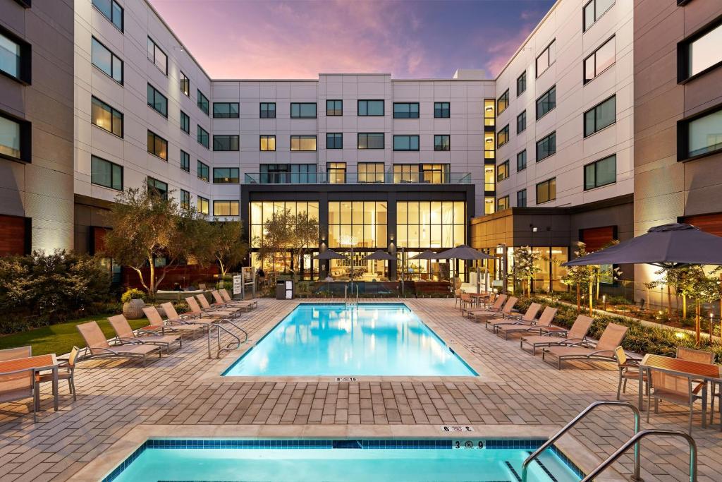 圣克拉拉Element Santa Clara的一座带游泳池和椅子的酒店和一座建筑