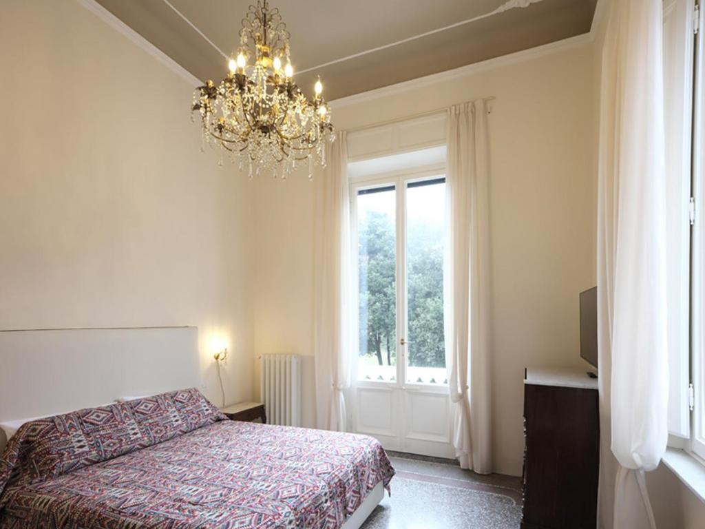 维亚雷焦Villa Giulia BnB的一间卧室配有一张床、一个吊灯和一扇窗户