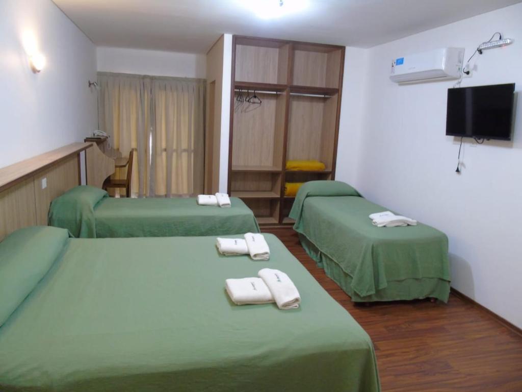 波萨达斯芦荻公寓酒店的客房设有两张带毛巾的绿色床。