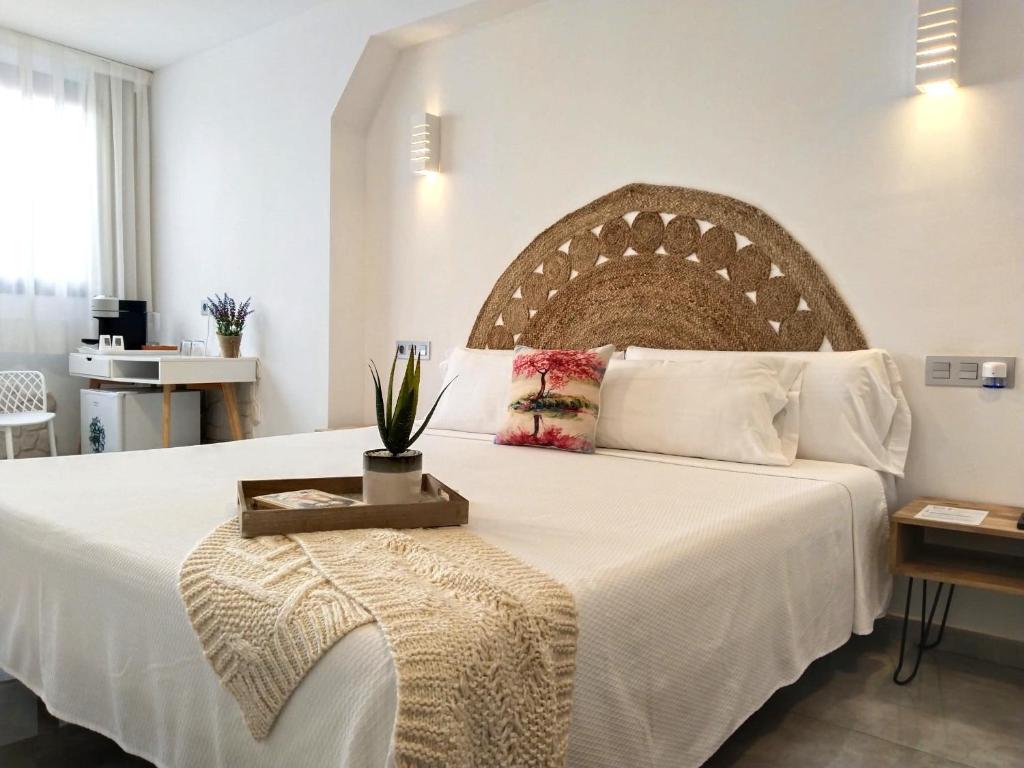 卡沃内拉斯Hostal Aires del Mar的卧室配有一张白色大床和木制床头板
