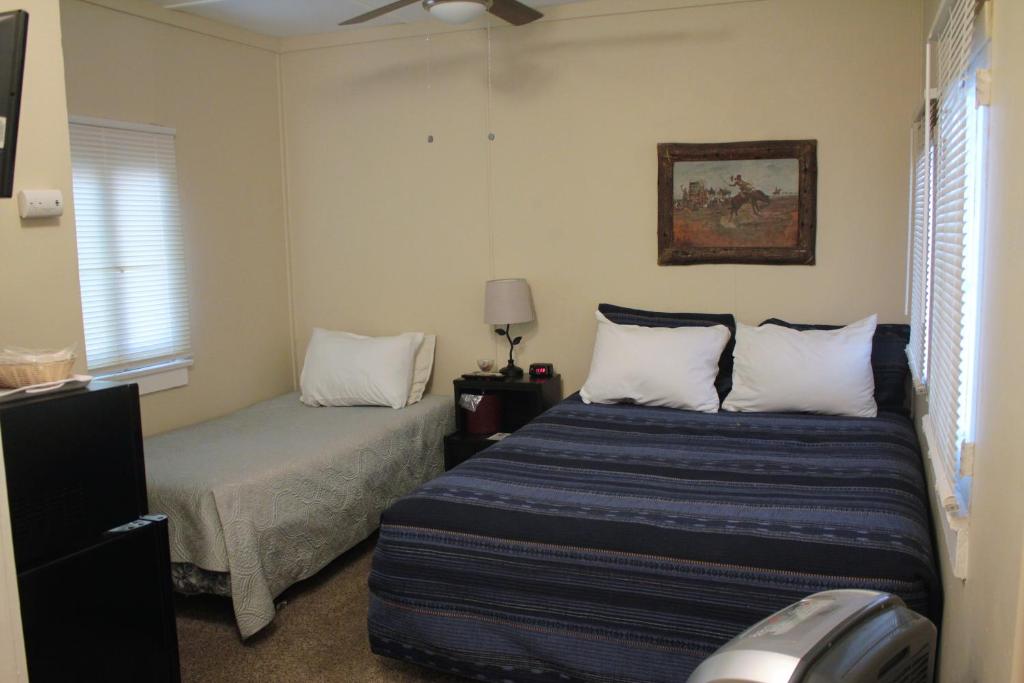 ChlorideGrand Canyon West Hotel Sheps Miners Inn的一间卧室配有两张床和吊扇