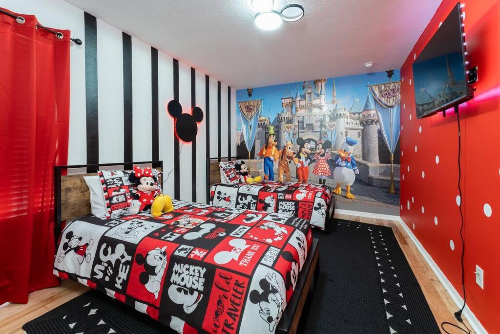 奥兰多The Dream Vacation Home!的一间卧室配有两张床和一张迪斯尼壁画