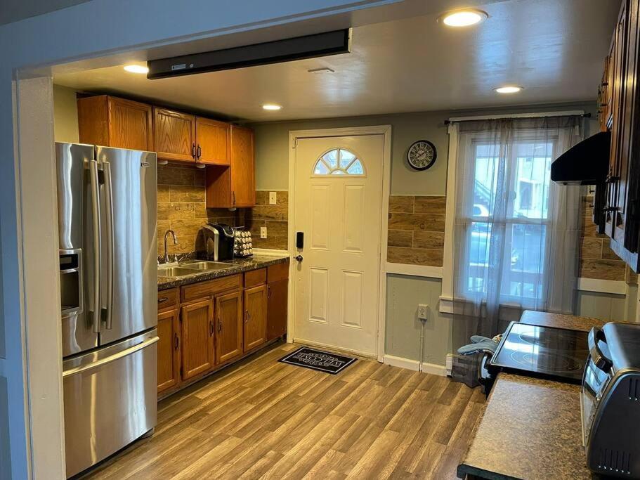 东哈特福德Comfortable home away from home的厨房配有木制橱柜和带冰箱的门。