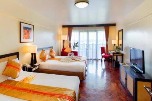 长滩岛Keira 208, Alta Vista De Boracay的酒店客房设有两张床和一台平面电视。