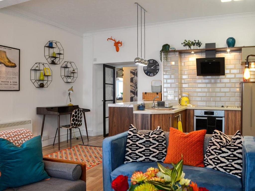 WhithornGeorge Apartment 54的一间带蓝色沙发的客厅和一间厨房