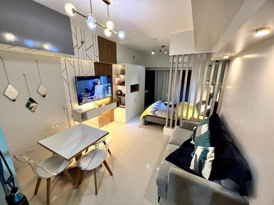 达沃市Davao City Serenity on Seventeenth One-Bedroom Condo beside Shopping Malls with Seaview and City view的客厅配有沙发、桌子和床。
