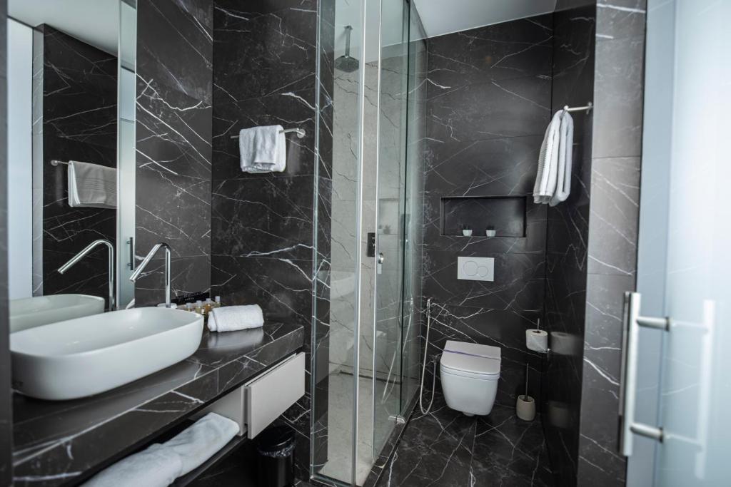 普里什蒂纳Venus Hotel的黑色浴室设有水槽和卫生间