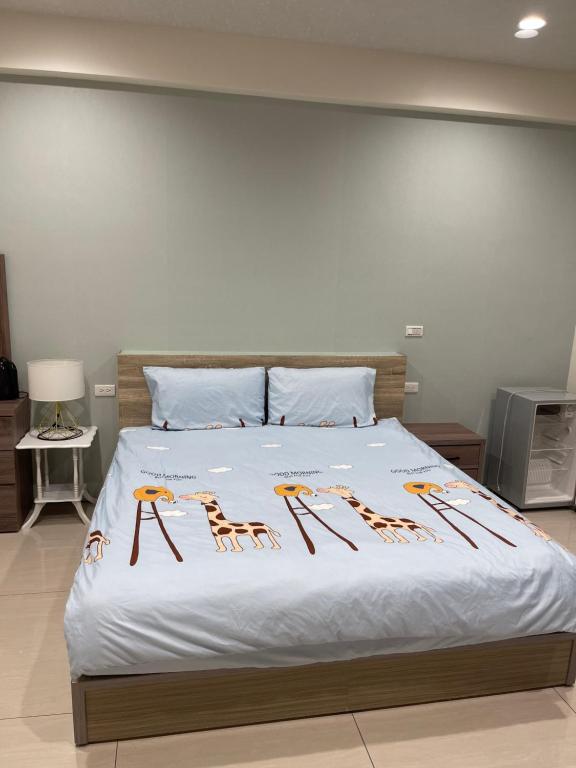 罗东镇羅東珍寶的一间卧室配有一张带白色床罩和马匹的床。