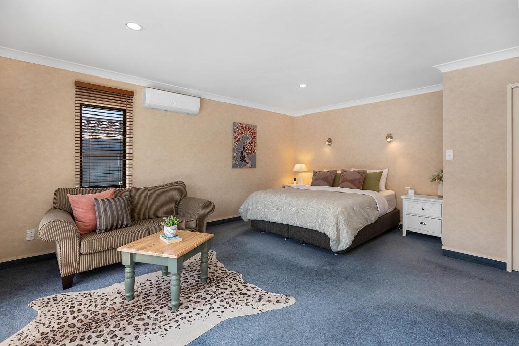汉密尔顿Hamilton Summer Treat- 4 Bedroom with pool的一间卧室，里面有一张床、一张沙发和一张桌子