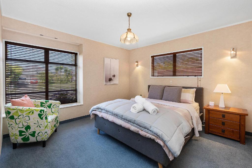 汉密尔顿Hamilton Summer Treat- 4 Bedroom with pool的卧室里有一张床和一把椅子