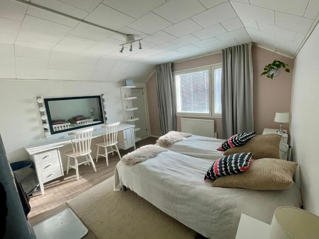 罗瓦涅米Villa Juuris的一间卧室配有两张床、一张桌子和一台电视。