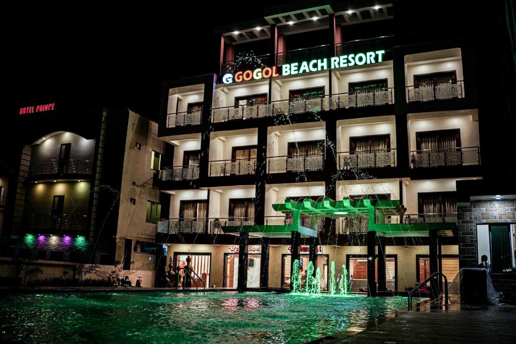 曼达莫尼Gogol Beach Resort的一座建筑,在晚上前方有一个喷泉