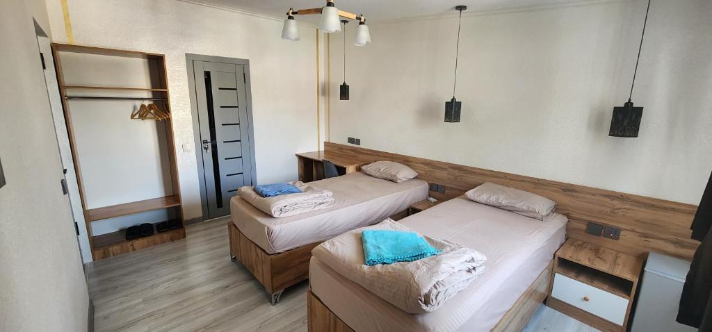 杜尚别绿屋旅舍的一间设有两张床和椅子的房间