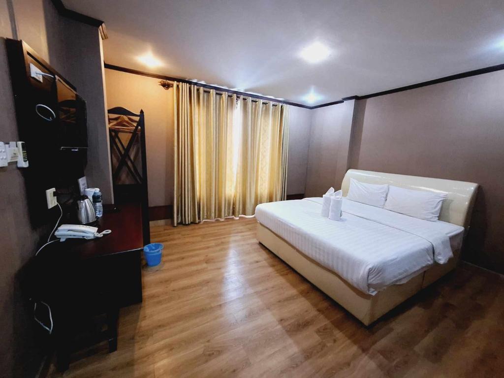 万象Sinakhone Vientiane Hotel的卧室配有白色的床,铺有木地板