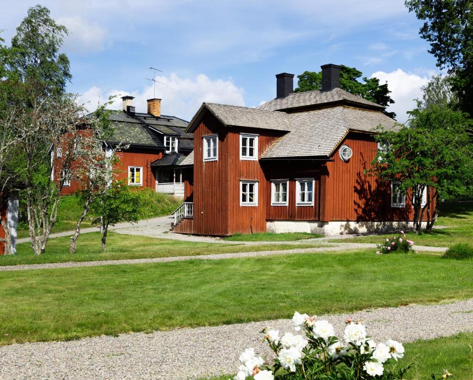 MalingsboProfessorsvillan - hyr hela huset的大型木制房屋设有白色窗户和庭院
