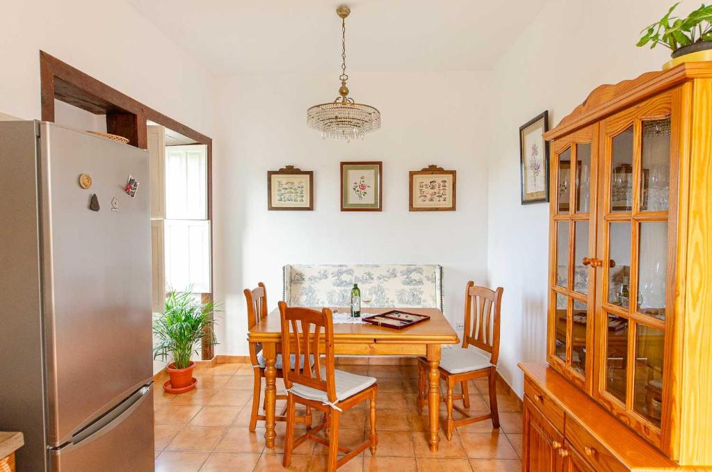 蓬塔戈尔达Pino Redondo的厨房配有木桌和冰箱。