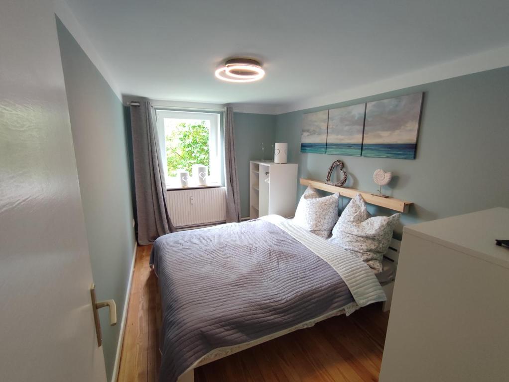 弗伦斯堡Ferienhaus Hygge的一间卧室配有一张带白色床单的床和一扇窗户。