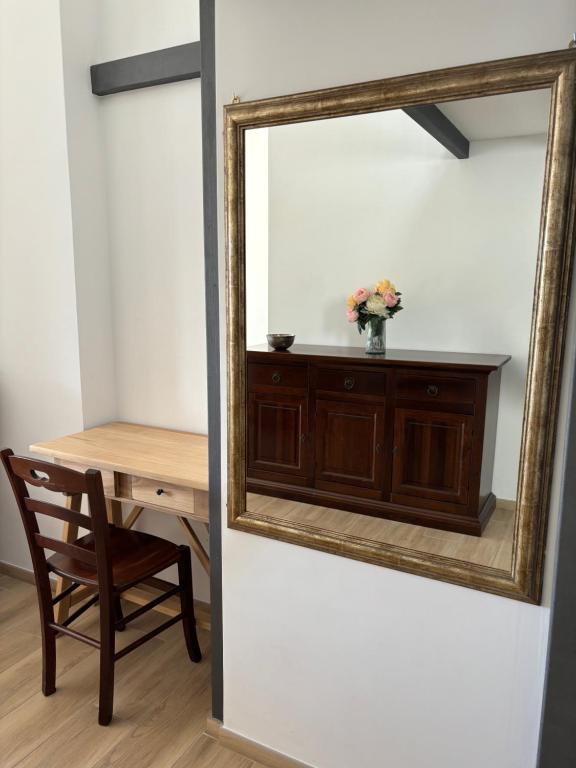 桑格罗堡Casa di Mirta的墙上的镜子,配有桌子和椅子