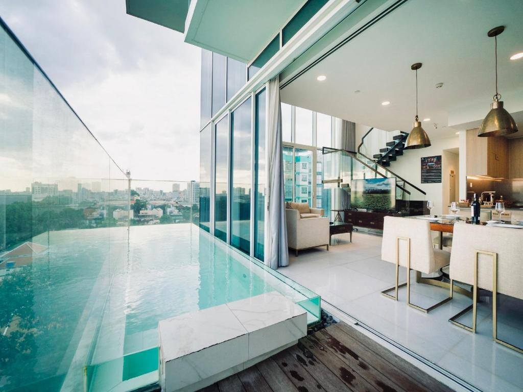 胡志明市Serenity Saigon Sky Villas的一座带玻璃墙的室内泳池