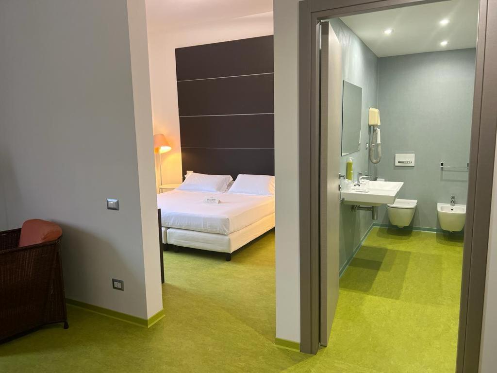 拉默齐亚泰尔默拉美齐亚大酒店的一间卧室配有一张床,浴室设有水槽