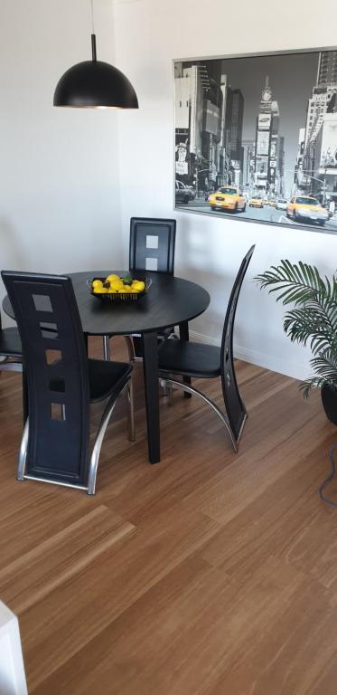 布里斯班Best Value With City View Sleeps 7的一张黑色餐桌,配有两把椅子和一盘香蕉