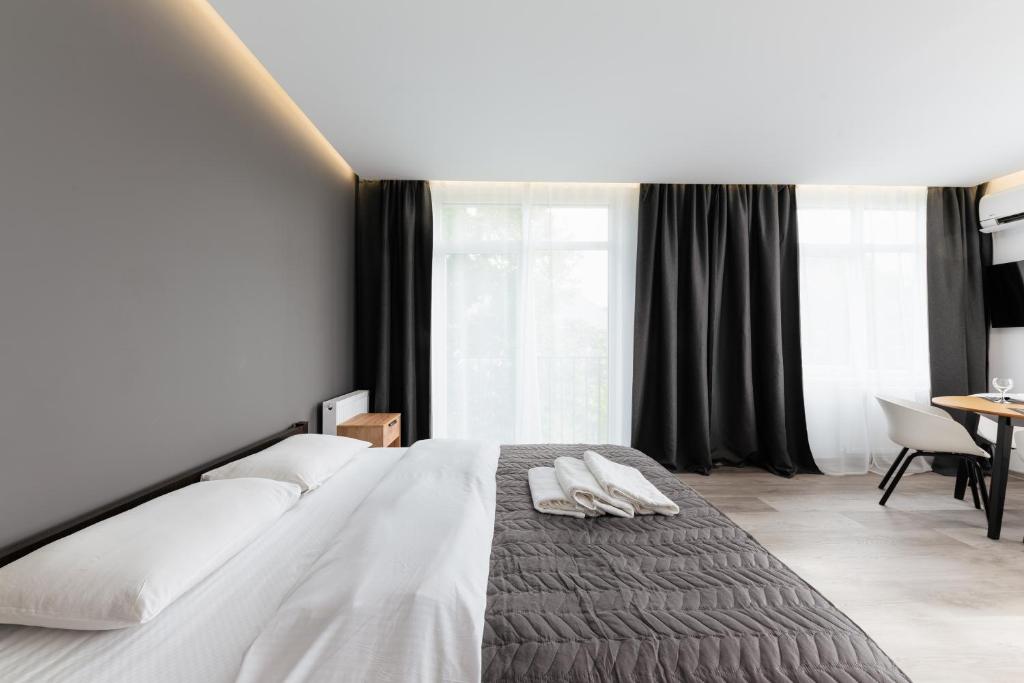 乌日霍罗德Luxury Apartments CITY的一间卧室配有一张大床和两条毛巾