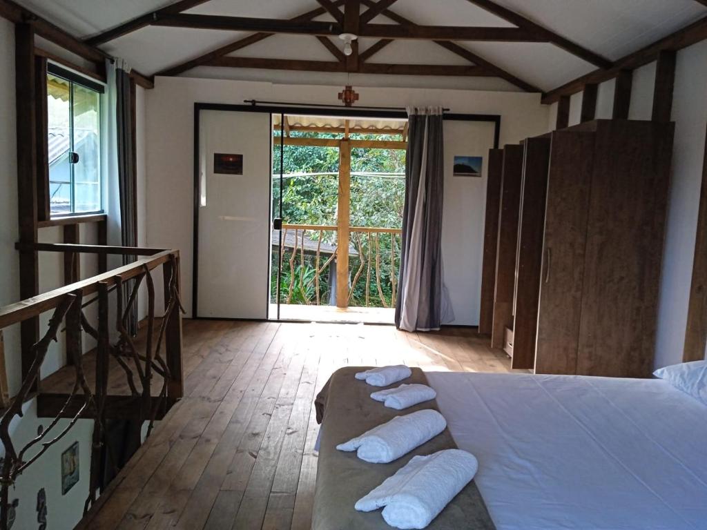 蜜岛Chalé Encantadas Eco Ilha Preserve的一间卧室配有一张带滚毛巾的床