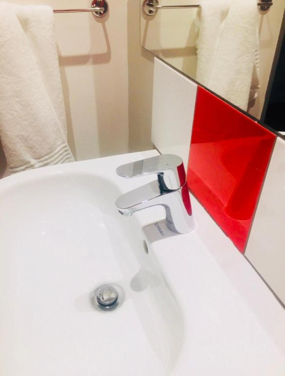 理查兹湾Pammy Guest House的白色浴室水槽和红色镜子