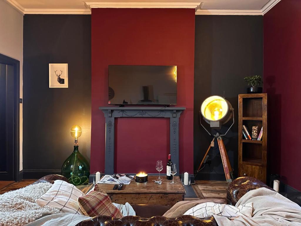 埃文河畔斯特拉特福The Bolt Hole的客厅设有红色的墙壁和镜子