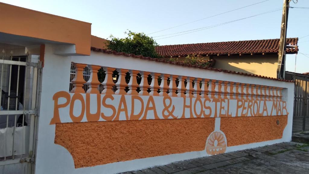蒙加瓜pousada&Hostel perola mar的建筑的侧面有标志