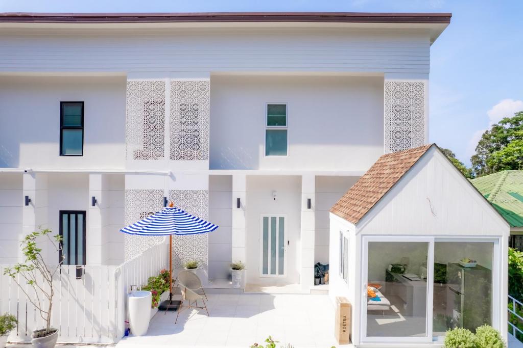 象岛Koh Chang Luxury Pool Villas的白色的房子,设有庭院和遮阳伞