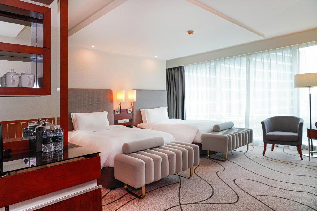 上海上海斯格威铂尔曼大酒店的酒店客房,配有两张床和椅子