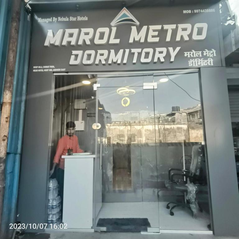 孟买Marol Metro Dormitory的站在商店橱窗柜台上的人